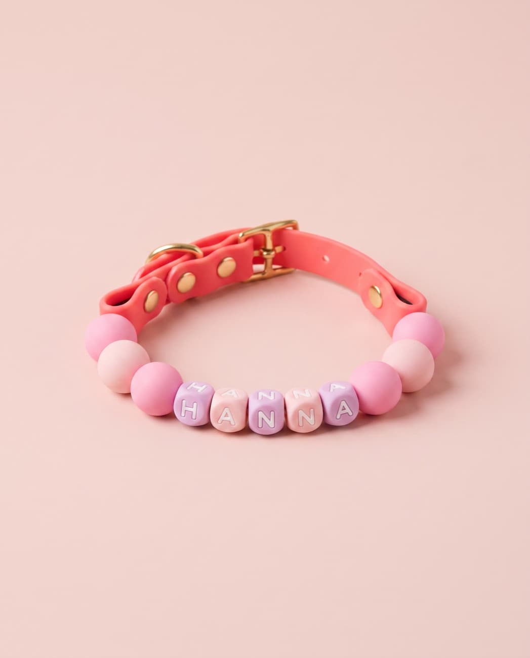 Pink and lilac beaded Cukie Crew collar spelling a pet's name on a blush background