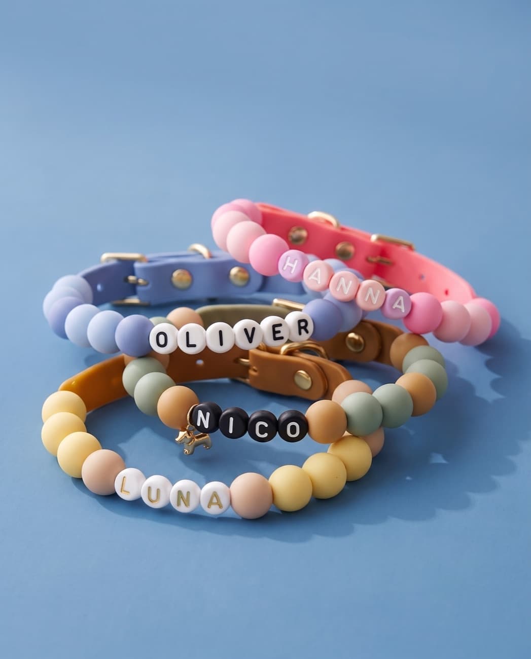 Four beaded collars in the full color palette stacked on a sky-blue background